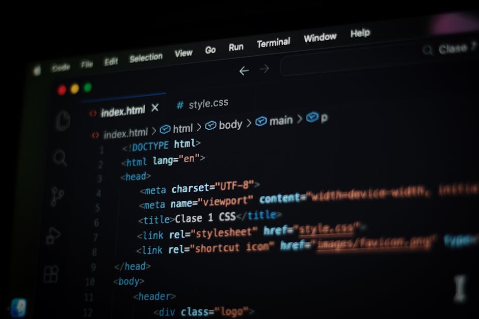 A close-up view of a computer screen displaying HTML code, including elements such as <html>, <head>, <title>, and <link>. The code features syntax highlighting with keywords in blue, attributes in or